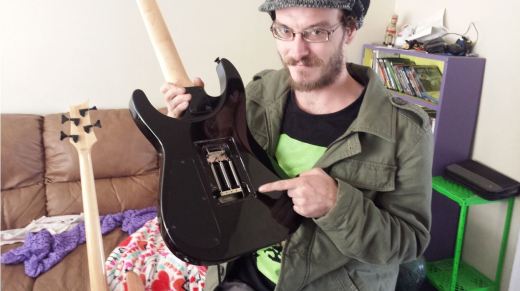 Linden Butler inspects an electric guitar at his house on a Saturday afternoon. Butler inspected the Floyd Rose system on a Jackson Dinky guitar, finding out why the strings would not stay in tune without yanking the tremolo, or “whammy bar”, up.